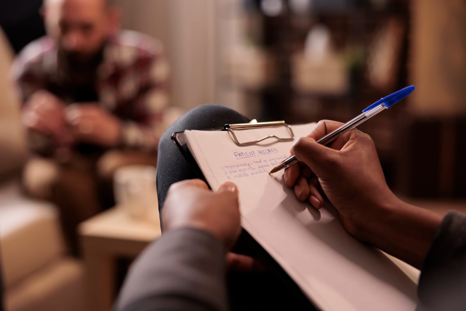 A psychologist writing case notes during a couples counselling session